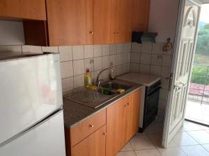 a kitchen with a sink and a refrigerator at Vasilis home apartment in Mazarakiá