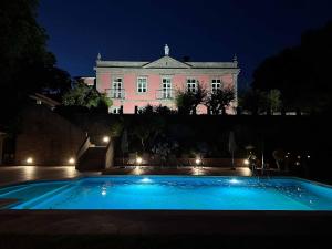 uma piscina em frente a um edifício à noite em Solar do Conde em Paredes de Coura