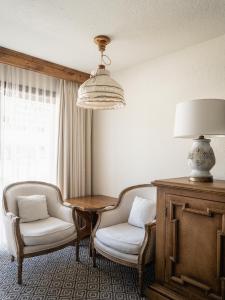 Habitación con 2 sillas, mesa y lámpara en Enzian Inn, en Leavenworth
