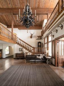 una gran sala de estar con una lámpara de araña y escaleras en Enzian Inn, en Leavenworth