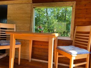 a table and two chairs and a window in a cabin at Zirkuswagen im Weserbergland in Aerzen