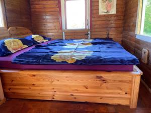 a bed in a cabin with a blue comforter on it at Zirkuswagen im Weserbergland in Aerzen