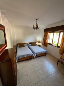 1 dormitorio con 2 camas, escritorio y ventanas en Apartamento en Nanin-Sanxenxo, en Sanxenxo
