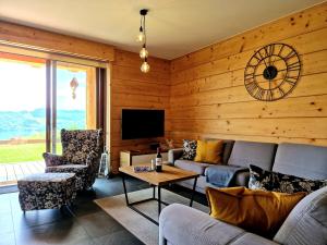 a living room with a couch and chairs and a tv at Exclusive apartment with sauna and garden on the Czorsztyn lake in Kluszkowce