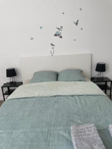 uma cama com um edredão verde e dois candeeiros em Villejuif - Métro Léo Lagrange - 2 pièces avec balcon em Villejuif