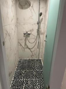 a bathroom with a shower with a black and white floor at Nonny and family lifestyle in Athens