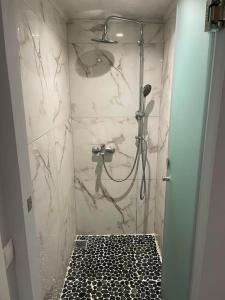 a bathroom with a shower with black and white tile at Nonny and family lifestyle in Athens