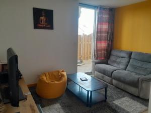 a living room with a couch and a table at Petite Auberge Landaise in Capbreton