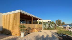 a small wooden house with a plant in front of it at Cottage JANICE Beach in Pakoštane