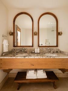 a bathroom with a large sink and two mirrors at Enzian Inn in Leavenworth