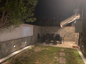 een tafel en stoelen in een achtertuin 's nachts bij 2DOORS & Free Parking in Larisa