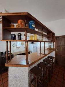 una cocina con estanterías y taburetes de madera en Las lavandas del colibrí, en Alpa Corral