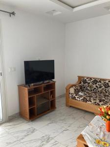 a living room with a flat screen tv and a couch at Grand appartement à 5minutes de la plage in El Maamoura