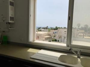 a kitchen counter with a window and a sink at Grand appartement à 5minutes de la plage in El Maamoura