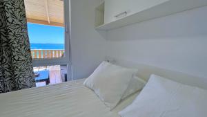 a bedroom with a bed with a view of the ocean at Cottage JANICE Beach in Pakoštane