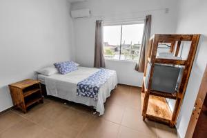 a bedroom with a bed and a mirror and a window at Pousada Silvestre in Tramandaí