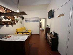 cocina y sala de estar con silla amarilla y sofá en Alloggio ad uso turistico Piave 47- Charlotte's Houses, en Gradoli