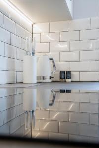 una cocina con paredes de azulejos blancos y una encimera. en Apartament Alpaka 1 en Lidzbark Warmiński