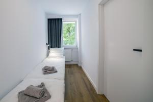 two beds in a room with a window at Apartament Alpaka 1 in Lidzbark Warmiński