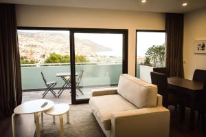 a living room with a couch and a table at CBA Suites Madeira in Funchal