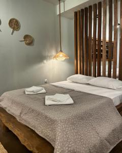 twee bedden in een kamer met witte handdoeken erop bij Elia’s Guest House in Paralia Saranti