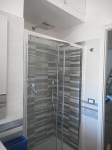 y baño con ducha y puerta de cristal. en Nuli' - Delizioso Appartamento, en Trapani