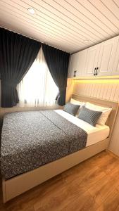 1 dormitorio con 1 cama grande y ventana en ELIES TINY GLAMPING en Ayvalık