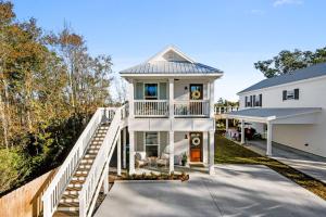 a white house with a staircase leading up to it at Cozy Vacation Rental in Old Town Bay St Louis close to beach, bars, and dining in Bay Saint Louis
