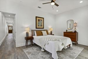 a white bedroom with a bed and a ceiling fan at Cozy Vacation Rental in Old Town Bay St Louis close to beach, bars, and dining in Bay Saint Louis