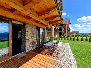 a wooden deck with a table and chairs on it at Exclusive apartment with sauna and garden on the Czorsztyn lake in Kluszkowce