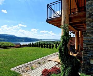 a porch of a house with a view of the water at Exclusive apartment with sauna and garden on the Czorsztyn lake in Kluszkowce