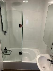 een douche met een glazen deur naast een wastafel bij Paddington house beautiful 2 bedroom terrace in Sydney