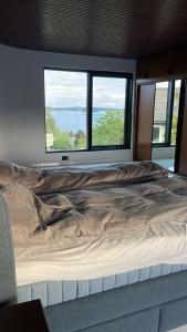 Cette chambre comprend un grand lit et une grande fenêtre. dans l'établissement Madla.Villa, à Stavanger