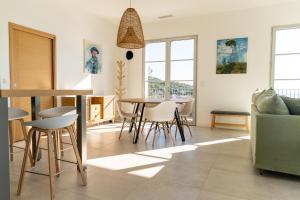 een woonkamer met een tafel en stoelen bij CHAPEAU LES ARTISTES in Brando