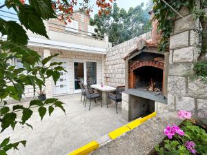 a patio with a table and a fireplace at Orhideja in Korčula