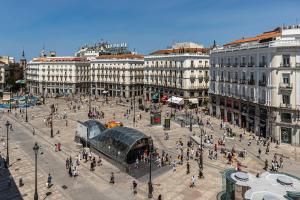 um grupo de pessoas andando em torno de uma praça em uma cidade em BNBHolder Apartamentos en Sol Deluxe 2 em Madrid