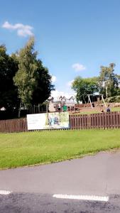 a park with a wooden fence and a playground at Brittany's in Gisburn