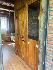 una puerta de madera en una habitación con una pared de piedra en Inn Harmony, en Kazbegi