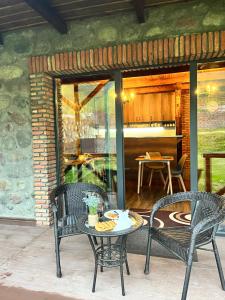 un patio con 2 sillas, una mesa y una mesa con sillas en Inn Harmony, en Kazbegi