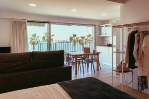 a bedroom with a bed and a kitchen with a view of the ocean at inspiramar in Benicarló