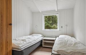 two beds in a room with a window at Strandbo in Thyholm