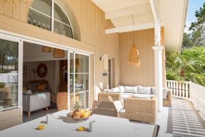 un porche de una casa con mesa y sillas en Belle villa familiale rénovée dans cadre exceptionnel-AG15, en Lacanau