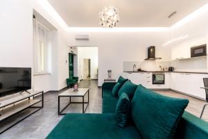 a living room with a green couch and a kitchen at High end 2 bedroom apartment in downtown in Budapest