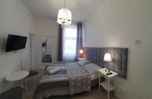 a bedroom with a bed and a desk and a table at Viator in Ustka