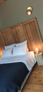 - une chambre avec un grand lit et une tête de lit en bois dans l'établissement Coeur de ferme en Pévèle, 