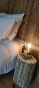 - une chambre avec un lit et une table avec une lampe dans l'établissement Coeur de ferme en Pévèle, 