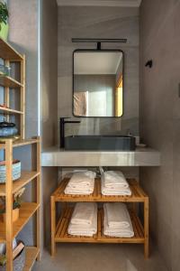 a bathroom with a sink and a mirror and towels at Villa Eliomylos in Souda