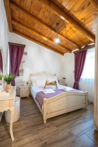 a bedroom with a bed and a wooden ceiling at Villa Eliomylos in Souda