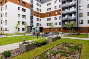 a courtyard in a building with benches and grass at Miejsko Tu - Opera #137 in Olsztyn