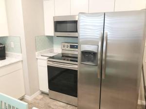 a kitchen with a stainless steel refrigerator and a microwave at Modern Apartment - 1 of 4 in Punta Gorda